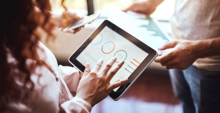 Business colleagues looking at business charts to assess financed emissions
